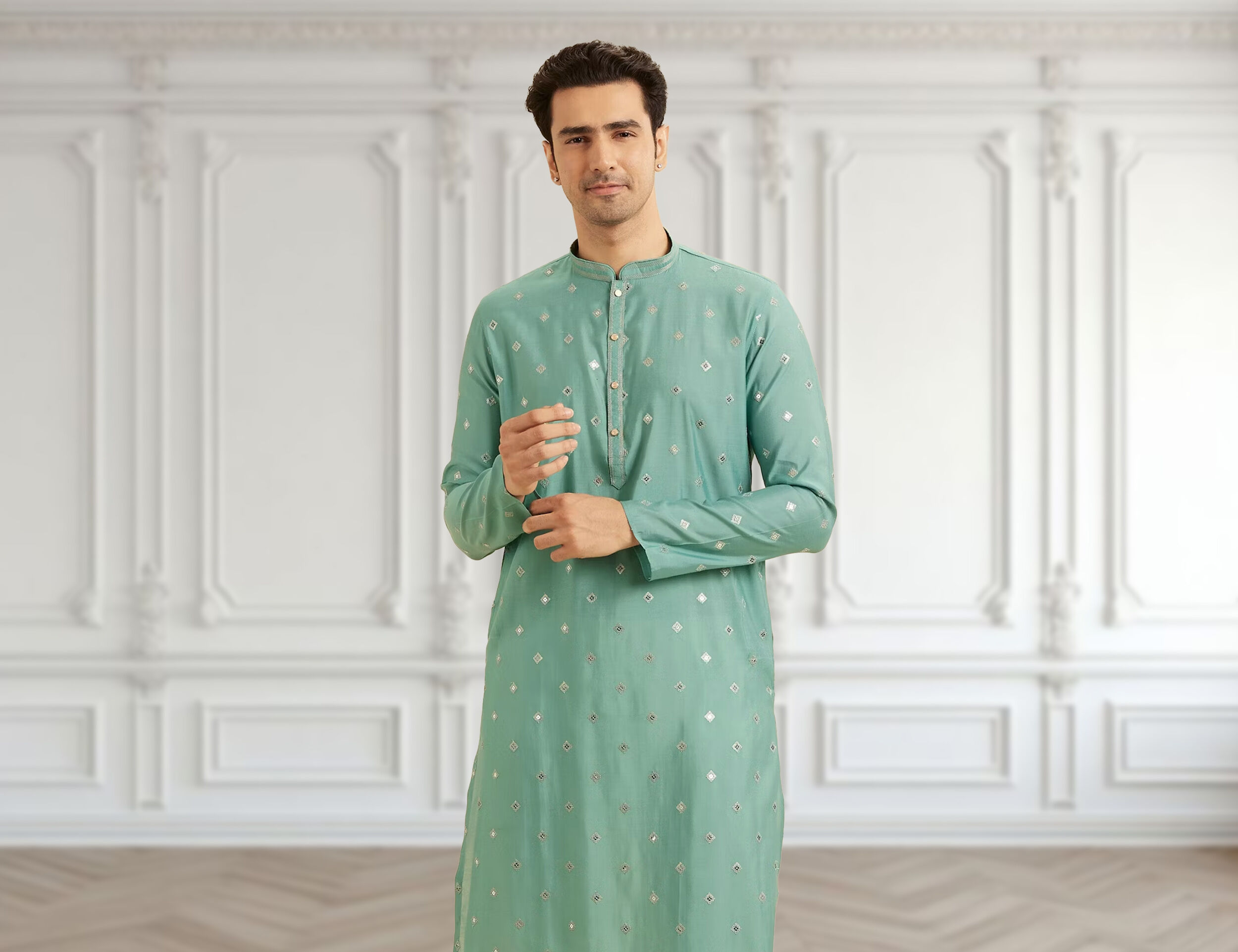 A stylish man modeling a green embroidered kurta, ready for a festive occasion